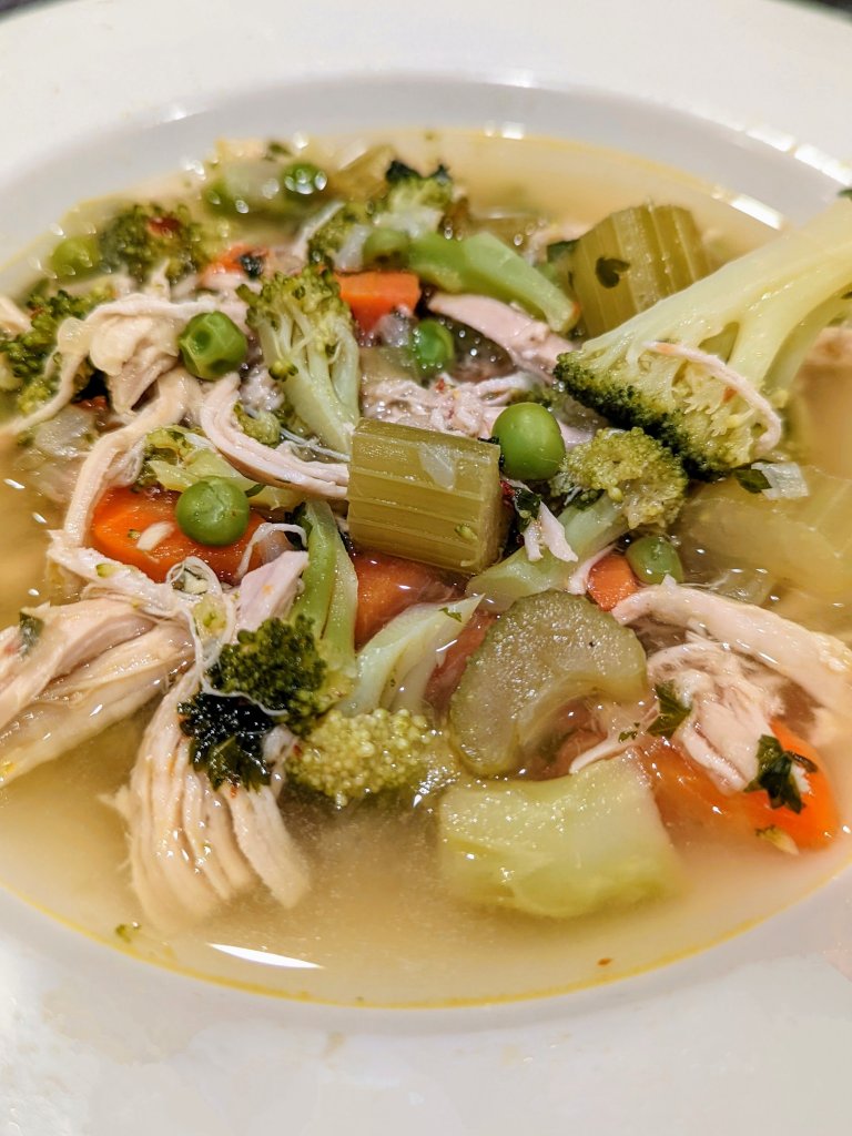 A bowl of chicken soup with plenty of vegetables